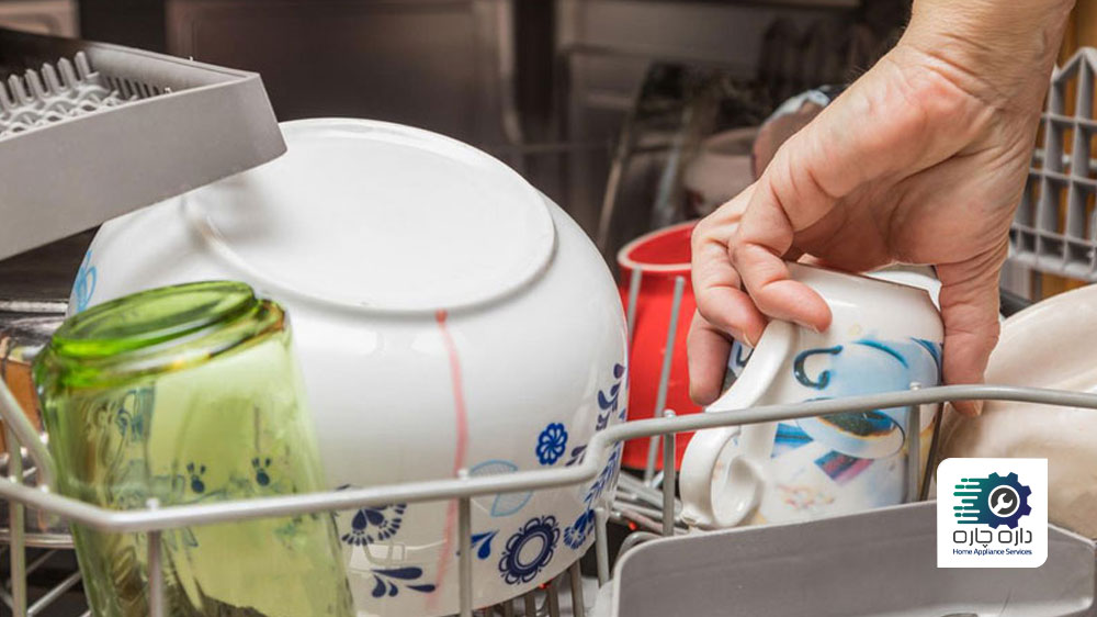 یک نفر در حال بررسی ظروف ماشین ظرفشویی که محلول شوینده بر روی آن پخش شده است