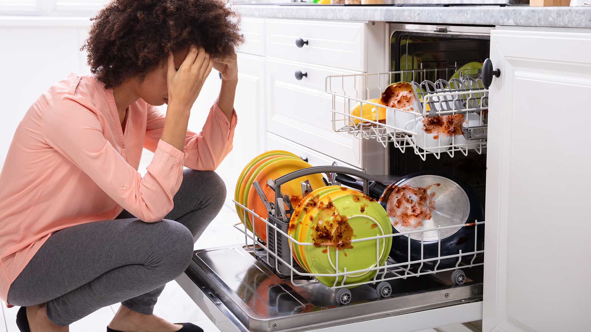 یک خانم که از تمیز نشدن ظروف در ماشین ظرفشویی کلافه است