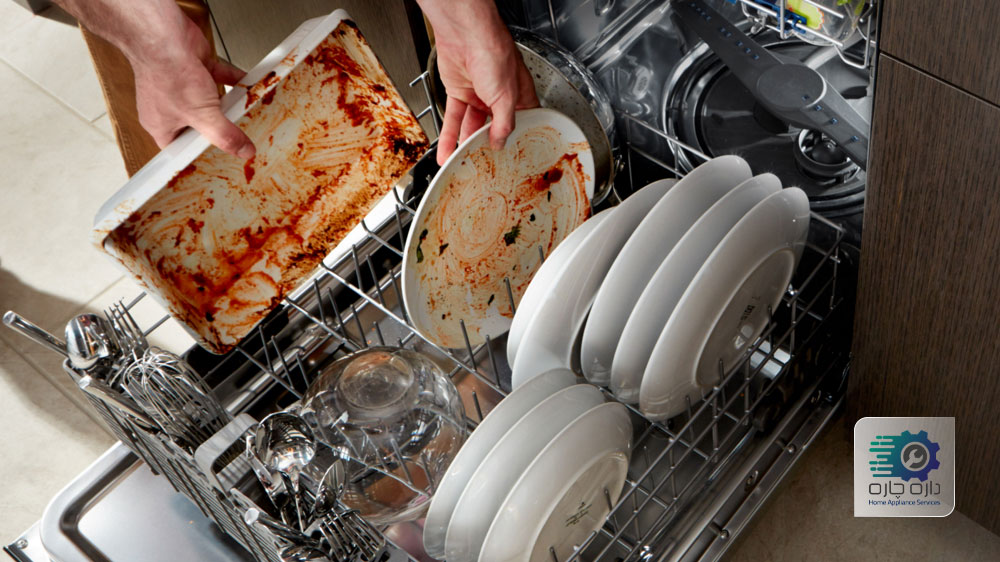 یک نفر در حال خارج کردن ظروف کثیف از ماشین ظرفشویی میدیا