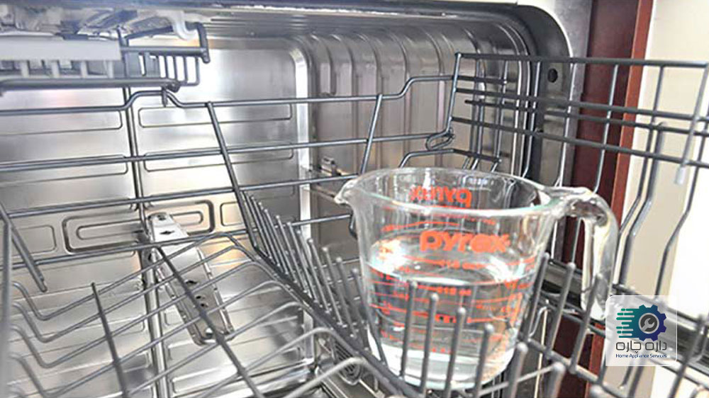 یک فنجان سرکه در قفسه ی بالای ماشین ظرفشویی قرار داده شده است.