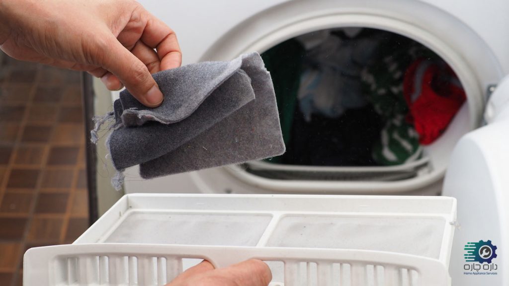 یک نفر در حال تمیز کردن پرزگیر خشک کن لباس