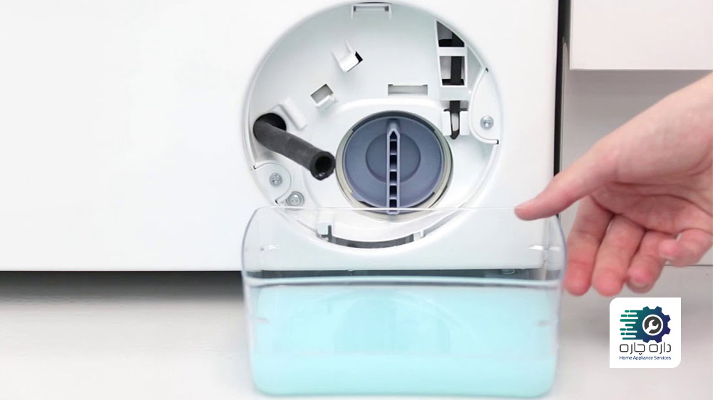 شخصی در حال خالی کردن آب درون محفظه فیلتر تخلیه ماشین لباسشویی زیمنس است