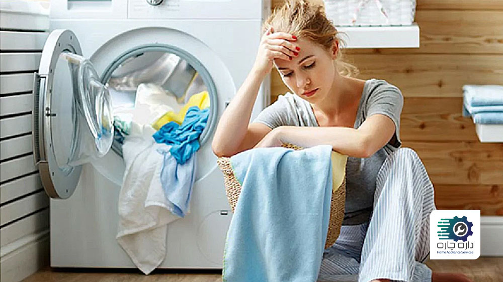 خانمی که به دلیل کار نکردن ماشین لباسشویی بکو ناراحت جلوی دستگاه نشسته است
