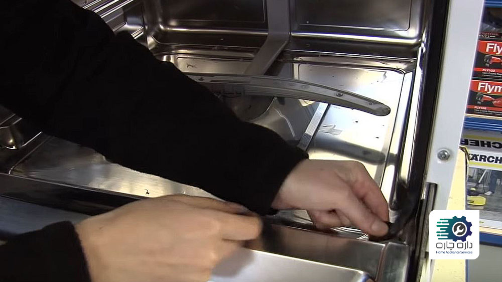 شخصی در حال برداشتن لاستیک درزگیر قدیمی ماشین ظرفشویی بوش