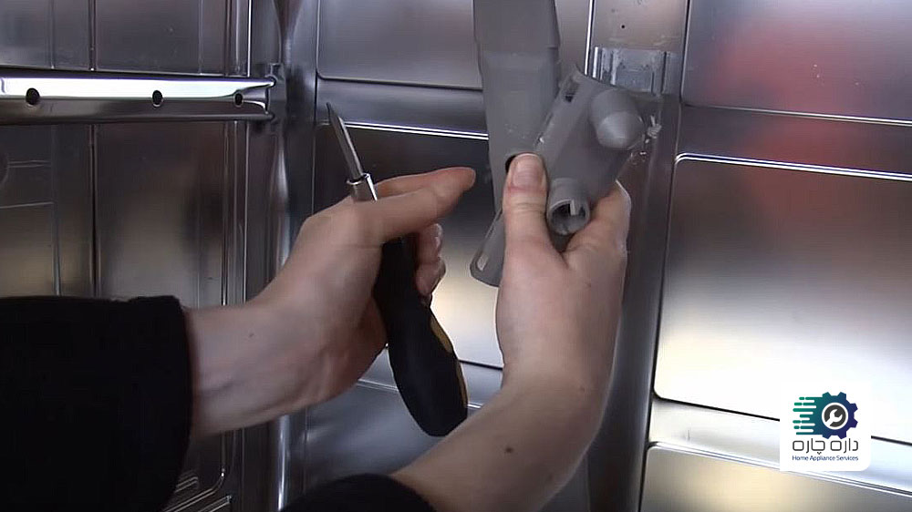 شخصی کانال تامین آب بازوی آبپاش و کانکتور آن را در ماشین ظرفشویی بوش جدا کرده است