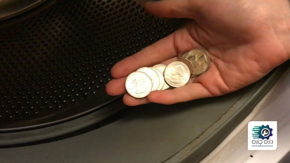 شخصی سکه هایی که درون درام ماشین لباسشویی زیرووات افتاده است را در دست گرفته