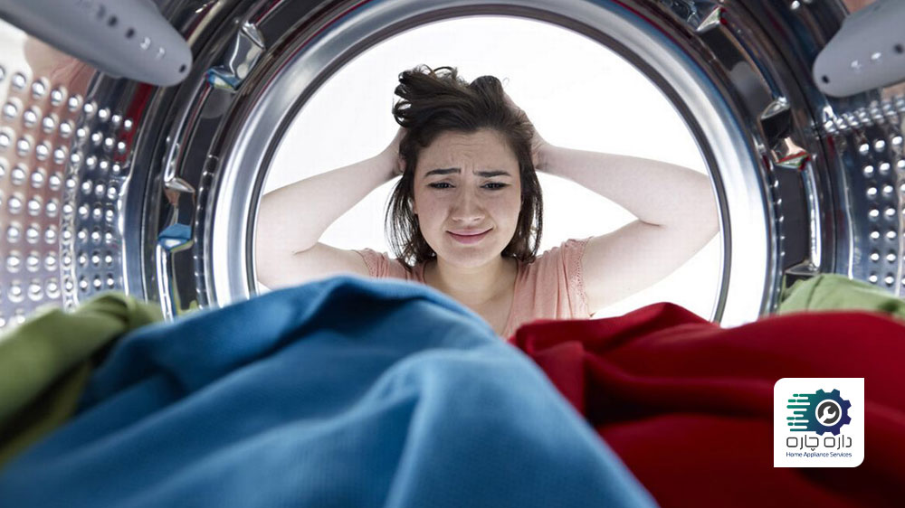 خانمی که به داخل درام ماشین لباسشویی ایندزیت نگاه می کند و به دلیل نچرخیدن درام عصبانی شده