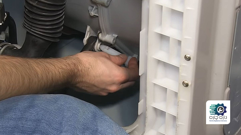 شخصی در حال نصب میخ پلاستیکی دمپر در ماشین لباسشویی ال جی