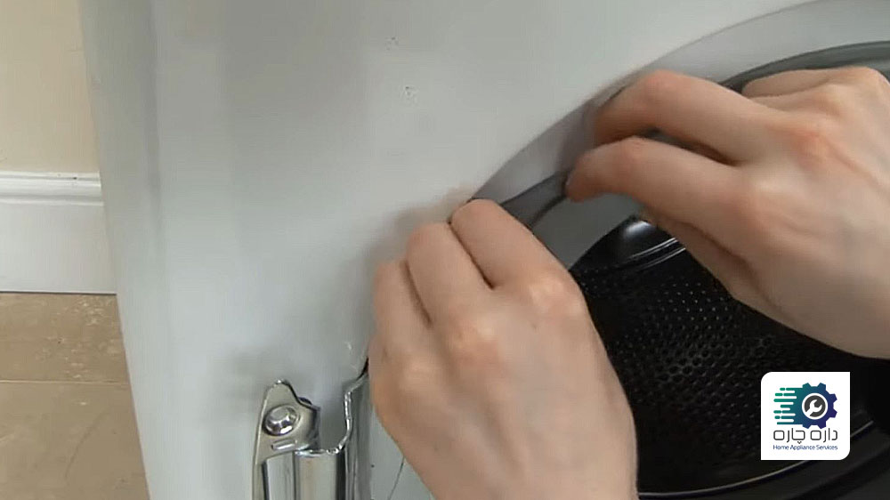 شخصی در حال جاگذاری لاستیک درزگیر دور درب ماشین لباسشویی آاگ