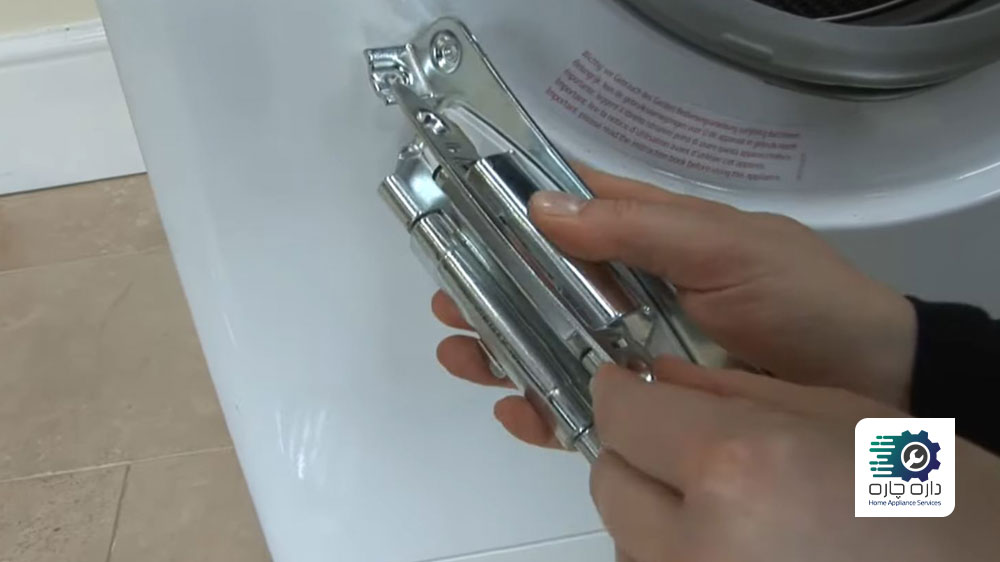 شخصی در حال نشان دادن نحوه قرارگیری لولای جدید درب ماشین لباسشویی آاگ در هنگام نصب