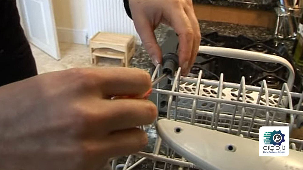 شخصی در حال جدا کردن چرخ های سبد ماشین ظرفشویی الکترولوکس به وسیله پیچ گوشتی
