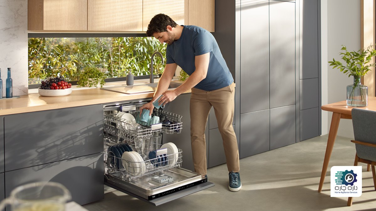 یک آقا در حال چیدن ظروف در ماشین ظرفشویی