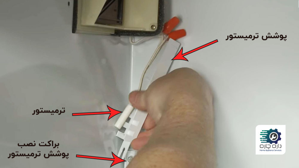 یک نفر در حال نصب ترمیستور جدید یخچال جنرال الکتریک
