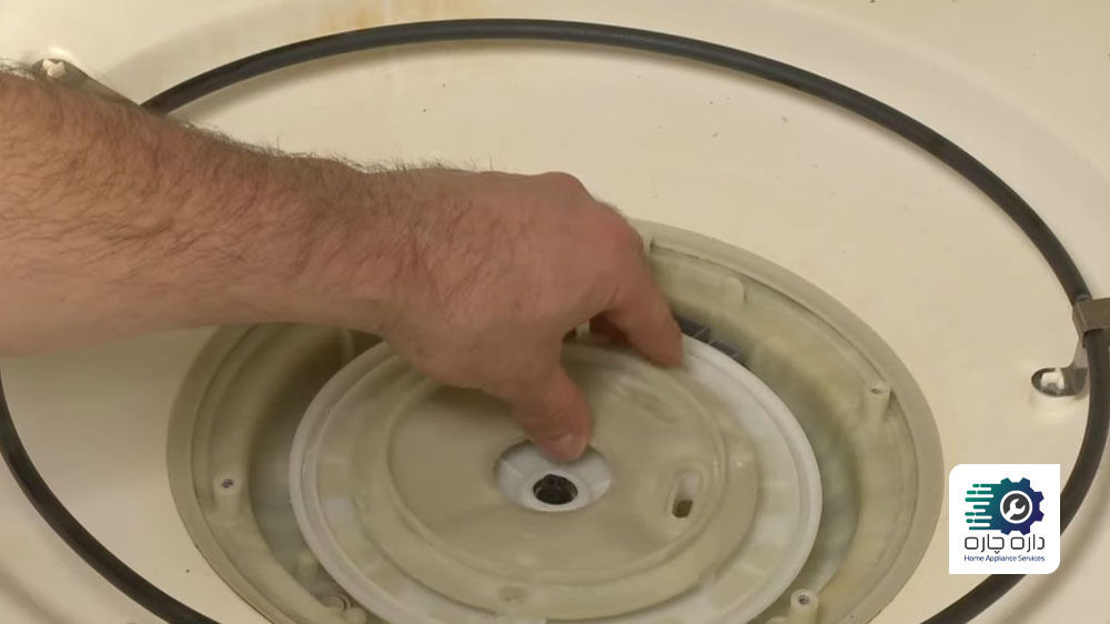 یک نفر در حال جاگذاری صفحه ساکشن و نگهدارنده فیلتر ماشین ظرفشویی می تگ