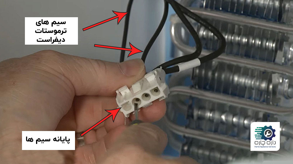 یک نفر در حال جدا کردن سیم های ترموستات دیفراست از پایانه سیم ها در یخچال فریزر فریجیدر