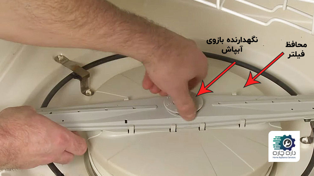 یک نفر در حال برداشتن نگهدارنده بازوی آبپاش پایینی ماشین ظرفشویی می تگ