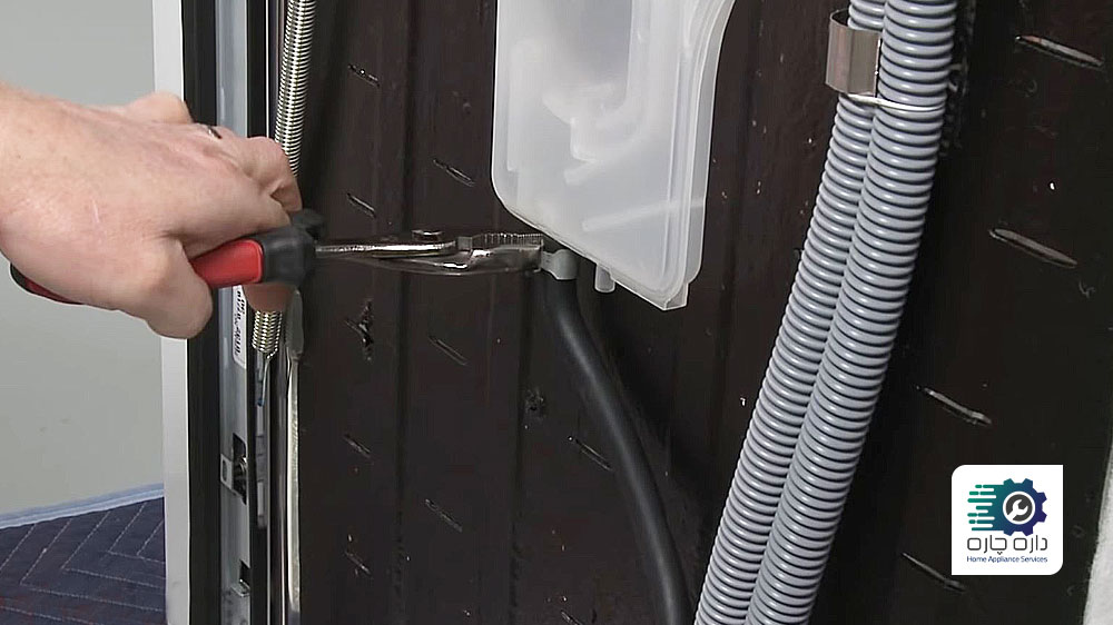 یک نفر در حال جدا کردن لوله هوا از ورودی آب ماشین ظرفشویی ال جی