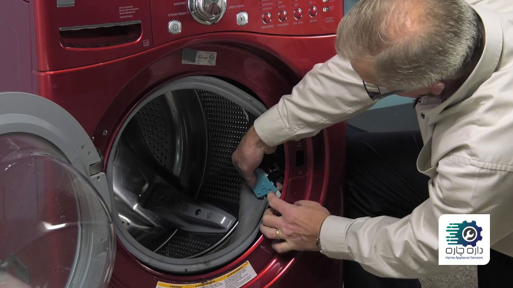 یک نفر در حال تعویض قفل درب ماشین لباسشویی ال جی است
