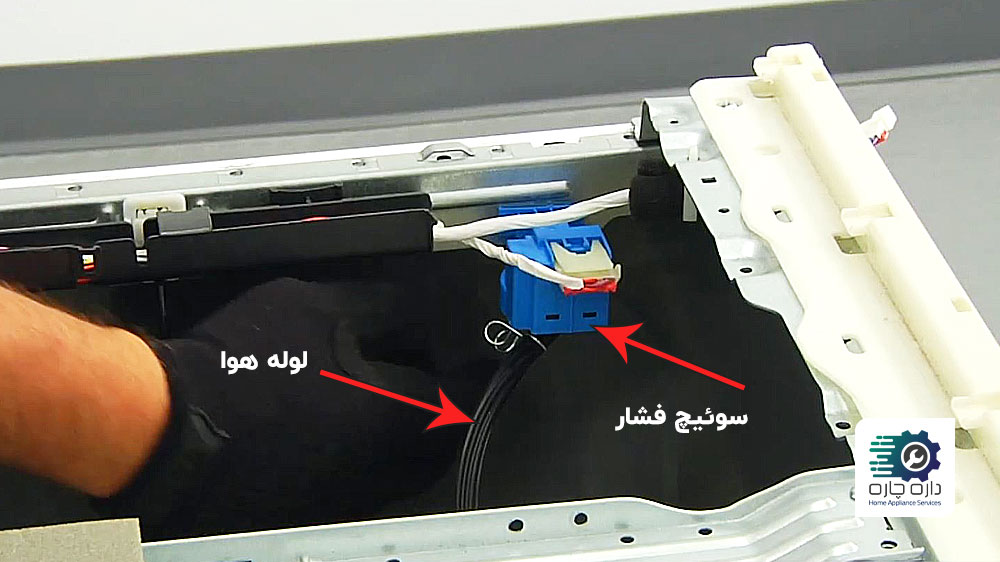 شخصی در حال جدا کردن لوله هوا از سوئیچ فشار ماشین لباسشویی سامسونگ
