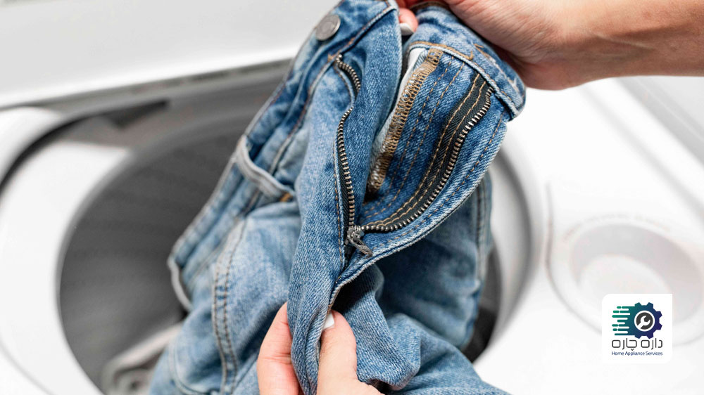 یک نفر شلوار جین را از ماشین لباسشویی بیرون آورده