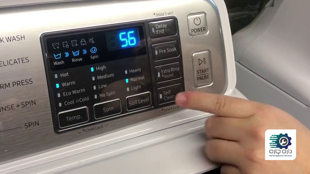 یک نفر در حال فشردن دکمه Self Clean در ماشین لباسشویی