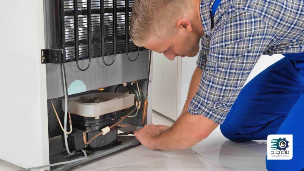 یک تعمیرکار در حال تعمیر کمپرسور یخچال فریزر است.