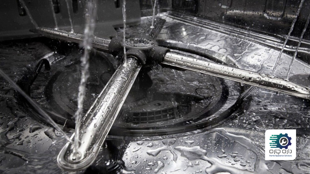 بازوهای آبپاش ماشین ظرفشویی در حال چرخش و پاشش آب است.