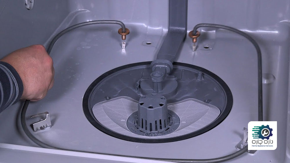 یک نفر در حال تعویض المنت حرارتی ماشین ظرفشویی